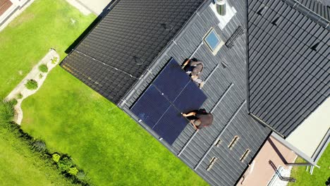 Two-Guys-Fixing-Solar-Panes-To-Roof---Aerial-Top-down-View