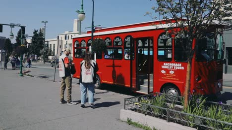 Tourists-Boarding-The-Trolley-At-The-Terminal-With-Alaskan-Guides-In-anchorage,-Alaska,-USA