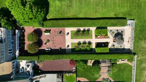 Top-down-aerial-of-manicured-gardens-and-rear-of-backyard-homes,-perfectly-maintained
