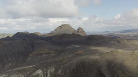 Toma-Aérea-Ascendente-Del-Paisaje-Volcánico-Domadalur-En-Islandia-Durante-El-Día-Nublado-Y-Soleado
