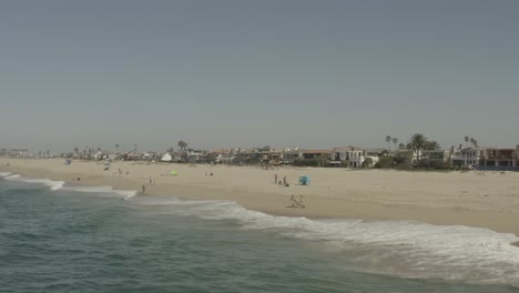 Beautiful-aerial-drone-of-California-coastal-beach-with-surfers---Graded