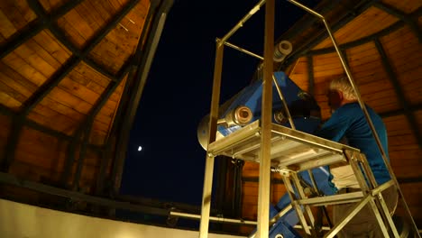 Mann-Benutzt-Großes-Teleskop-Im-Observatorium,-Um-Den-Mond-Am-Nachthimmel-Zu-Betrachten