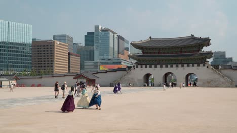 Lugareños-Y-Turistas-Disfrazados-De-Hanbok-En-El-Palacio-Gyeongbokgung-Con-La-Puerta-Gwanghwamun-Y-El-Horizonte-De-Seúl-Al-Fondo-En-Corea-Del-Sur