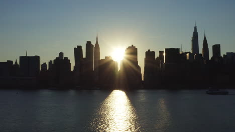 Standaufnahme-Zu-Beginn-Des-Seltenen-Manhattanhenge-Phänomens-Mit-Einem-Intensiven-Sonnenstrahl,-Der-Zwischen-Den-Gebäuden-Der-Legendären-Skyline-Hervorschießt