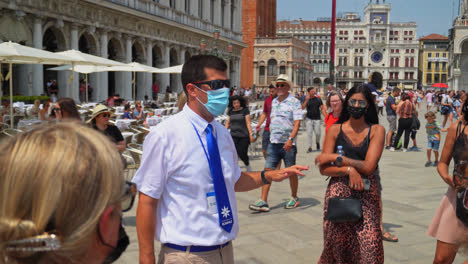 Tour-Guide-In-Mask-Explaining-The-Itinerary-To-Tourists-In-Venice,-Italy
