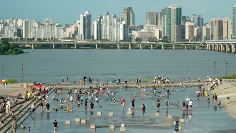 Los-Niños-Disfrutan-Del-Juego-Acuático-En-La-Plaza-De-La-Cascada-Del-Parque-Yeouido-Hangang---Vista-Aérea