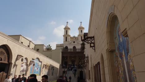 People-walking-outside-the-The-Hanging-Church,-Saint-Virgin-Mary's-Coptic-Orthodox-Church,-Egypt