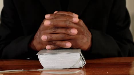 man-praying-with-hand-on-bible-black-background-stock-footage