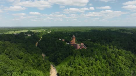 On-a-summer-day,-a-panoramic-aerial-view-of-Turaida-Castle,-which-is-built-on-a-mountain-in-a-wooded-area-of-Latvia