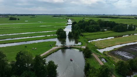 Motorboat-on-river-through-wet-lush-Krimpenerwaard-polder-farmland