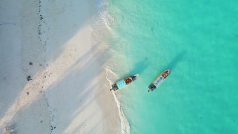 Nungwi-Beach,-Zanzibar---Tanzania---June-18,-2022---Boats-on-the-Indian-ocean-on-a-sunny-cloudy-day-during-sunrise