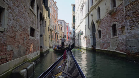 Gondoliers-Take-Tourists-On-A-Traditional-Boat-Ride-Through-The-Charming-Canals-In-Venice,-Italy