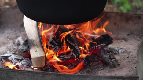 Slow-motion-of-outdoor-wood-cooking-fire-heating-cauldron,-or-bogrács