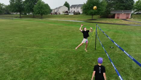 Teenage-friends-play-volleyball-outside-on-summer-vacation