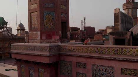 Aerial-Rising-View-Outside-Wall-Of-Wazir-Khan-Mosque-Towards-Tip-Of-Minaret-In-Lahore