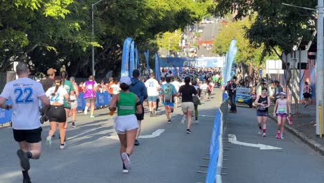 Teilnehmer-Rennen-Mit-Freude-Und-Schweiß-Auf-Die-Ziellinie-Zu,-Spendenaktion-„Bridge-To-Brisbane“,-Um-Spenden-Für-Wohltätige-Zwecke-Zu-Sammeln,-Menschen-Zeigen-Liebe-Und-Unterstützung-Für-Einen-Guten-Zweck,-Bewegungsaufnahme-Aus-Der-Hand