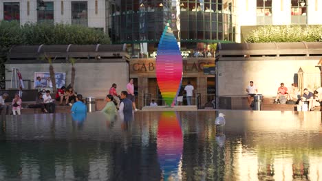 Canary-Wharf-Londres-Inglaterra-Junio-2022-Orgullo-Tributo-Escultura-Girando-Junto-A-La-Fuente-De-La-Plaza-Cabot-Con-El-Reflejo-Reproduciéndose-A-Través-Del-Agua