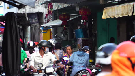 Vietnamesische-Marktstraße-Mit-Sich-Unterhaltenden-Händlern-Und-Leuten,-Die-Mit-Ihren-Fahrrädern-Herumfahren