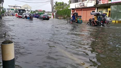 Carretera-Inundada,-Después-De-Una-Tormenta-Tropical-En-La-Ciudad-De-Dagupan,-Vehículos-De-Pasajeros-Y-Vehículos-Públicos-Conduciendo-Lentamente-A-Través-De-Una-Carretera-Sumergida