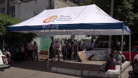 La-Gente-Espera-A-La-Sombra-A-Que-Llegue-La-Ayuda-Alimentaria-Bajo-Una-Carpa-De-Cocina-Central-Mundial-En-Un-Centro-De-Distribución-De-Mykolaiv-Durante-La-Guerra-Rusa-En-Ucrania