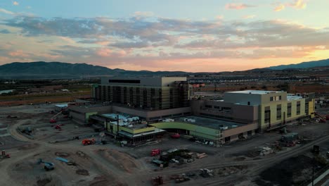 Orbiting-aerial-hyper-lapse-of-the-construction-site-for-a-hospital-at-sunset