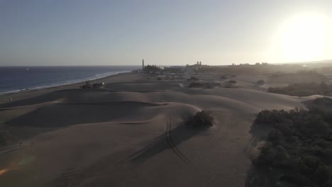 People-walking-at-Maspalomas-golden-sand-dunes,-stunning-sunset,-Gran-Canaria