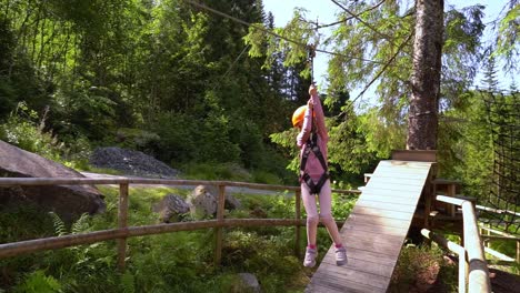 Kleines-Weibliches-Kind,-Das-Auf-Einer-Kleinen-Seilrutsche-Im-Voss-Kletterpark-In-Norwegen-Fährt-–-Zeitlupe-Folgt-Der-Bewegung-Der-Seilrutsche,-Während-Die-Mutter-Mit-Dem-Handy-Filmt