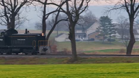 A-Lonely-Diesel-Locomotive-Traveling-Along-a-Single-Track-on-a-Winter-Day