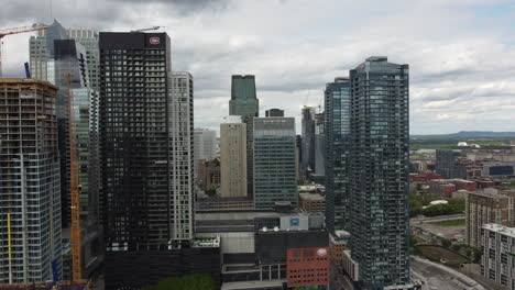 Vista-Aérea-Del-Centro-De-Montreal,-Canadá,-Volando-Hacia-Edificios-De-Torres-De-Arquitectura-Moderna-Y-Condominios,-Torres-Canadienses-En-El-Distrito-De-Bell-Center,-Desarrollo-Urbano-Y-Paisaje-Urbano