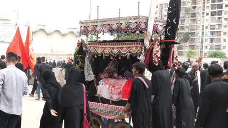 People-carrying-Tajia-in-the-crowd-of-mourners-at-the-Muharram-juloos-or-parade,-also-known-as-Muharram-Ul-Haram