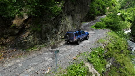 Blue-Nissan-Xterra-Suv-Conduciendo-Por-Una-Peligrosa-Carretera-De-Montaña-En-El-Parque-Nacional-Tusheti-En-Georgia