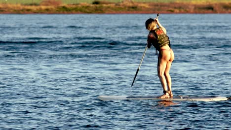 Una-Mujer-En-Bikini-Remando-En-El-Lago-Paranoa-En-Brasilia,-Brasil