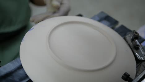 Pad-Machine-Stamp-Text-on-Back-of-White-Ceramic-Plate,-Close-Up