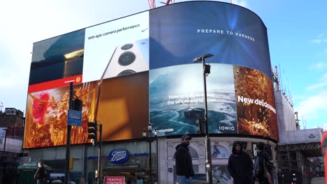 Piccadilly-Circus-video-screens-with-double-decker-bus,-low-angle-wide-shot