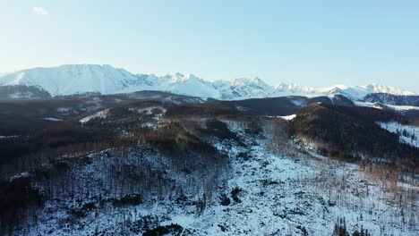 Morning-at-Tatra-Mountains-with-white-peaks-and-forest-slopes,-aerial