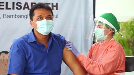 Yogyakarta,-Indonesien---15.-Feb-2021:-Männlichen-Gesundheitspersonal-In-Einem-Krankenhaus-Wird-Der-Corona-virus-impfstoff-Injiziert