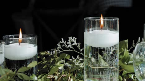 Wunderschöne-Hochzeitstischdekoration,-Flache-Lage-Aus-Weißen-Schwebenden-Brennenden-Kerzen-In-Vasen-Und-Wunderschönen-Pflanzlichen-Blumenarrangements
