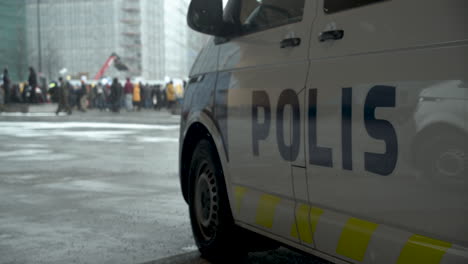 Plano-General-De-Una-Furgoneta-Policial-Con-Los-Manifestantes-Reunidos-En-Helsinki-Por-Las-Restricciones-De-Covid-19-En-El-Fondo