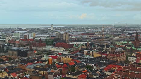 Colorful-downtown-rooftops-of-Malmo-city-in-ascending-drone-view