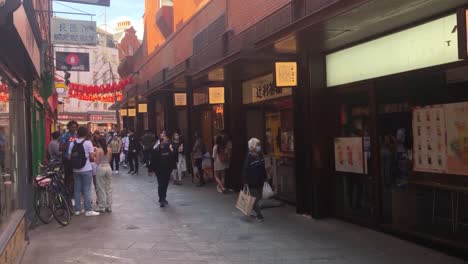 People-enjoy-a-walk-and-some-shopping-in-China-Town-London,-UK