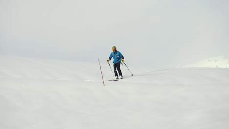 Action-shot-of-skier-sliding-and-slaloming-down-white-snowy-slope