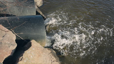 Nahansicht-Des-Wassers,-Das-Aus-Großen-Abwasserrohren-In-Den-See-Fließt