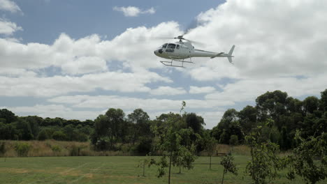Helicóptero-Graficado-En-Cámara-Lenta-Sobrevuela-Para-Aterrizar-Sobre-Un-Campo-De-Hierba