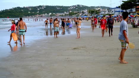 Dolly-in-of-people-having-fun-and-playing-in-the-seashore-of-Bombas-and-Bombinhas-beaches,-Brazil