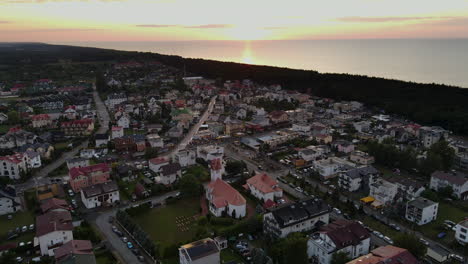 City-of-seaside-village-Karwia,-Poland-with-sunset-in-the-background