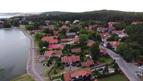 Nida-town-in-Neringa,-Lithuania-in-aerial-drone-ascending-to-high-altitude-view