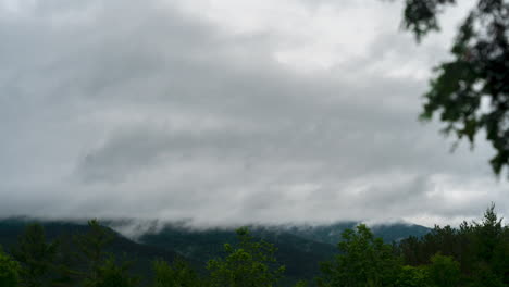 Fog-and-clouds-raining-over-lush-green-forest-and-mountains-timelapse