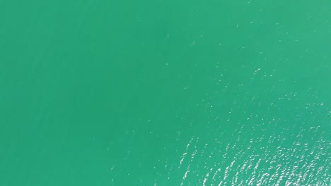 Luftaufnahme-Von-Strahlend-Blauem-Meerwasser-Mit-Sonnenlichtreflexionen
