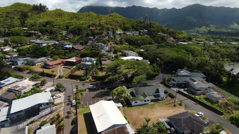 Drone-Flying-Over-Beautiful-Kaneohe-neighborhood-on-Oahu-in-Hawaii,-with-Mountain-Range-in-the-Distance