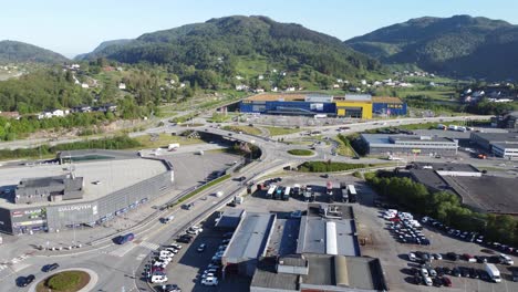Upward-moving-aerial-overview-of-massive-IKEA-building-and-Gullgruven-shopping-mall---Highway-with-heavy-traffic-in-surroundings---Clear-summer-day-Asane-Norway